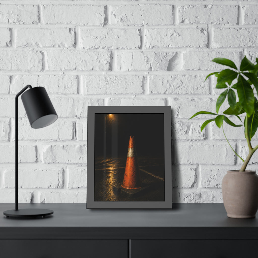 A battered orange traffic cone on wet asphalt under a street lamp. The Warning Without Danger by Garabaggio, framed fine art print hanging in a room.