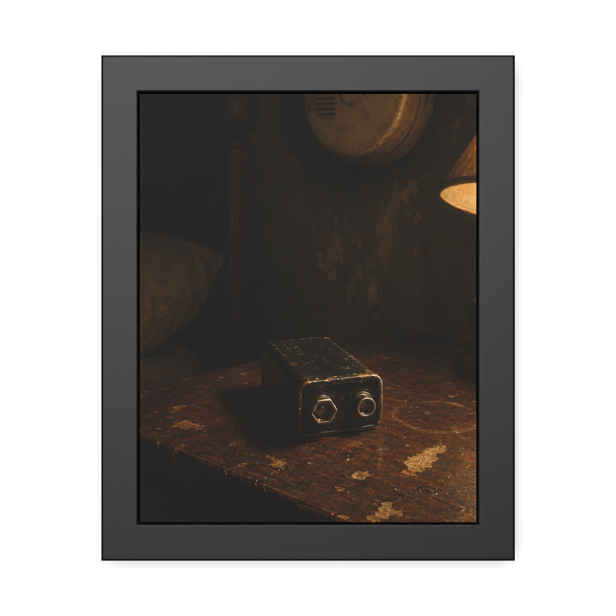 A nine volt battery on a nightstand below a wall smoke detector. The Battery Laid Below by Garabaggio, framed fine art print, 11″ x 14″.