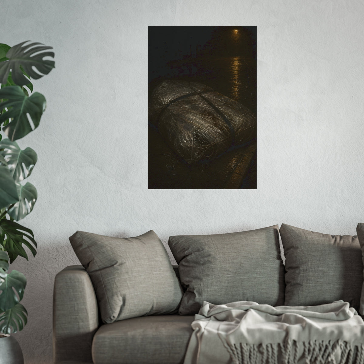 A mattress wrapped in plastic and strapped shut on a wet night street. The Municipal Shroud by Garabaggio, fine art print hanging in a room.