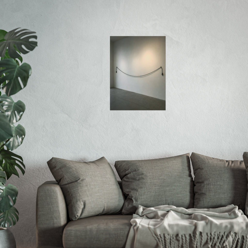 An extension cord hung in a long slack curve across a bare white wall. The Unplugged Line by Garabaggio, fine art print hanging in a room.