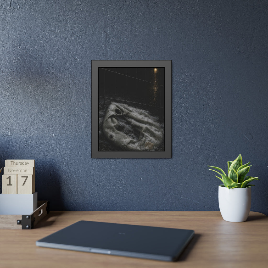 A deflated pool float under snow beside a chain link fence at night. The Bleaching Under Snow by Garabaggio, framed fine art print hanging in a room.