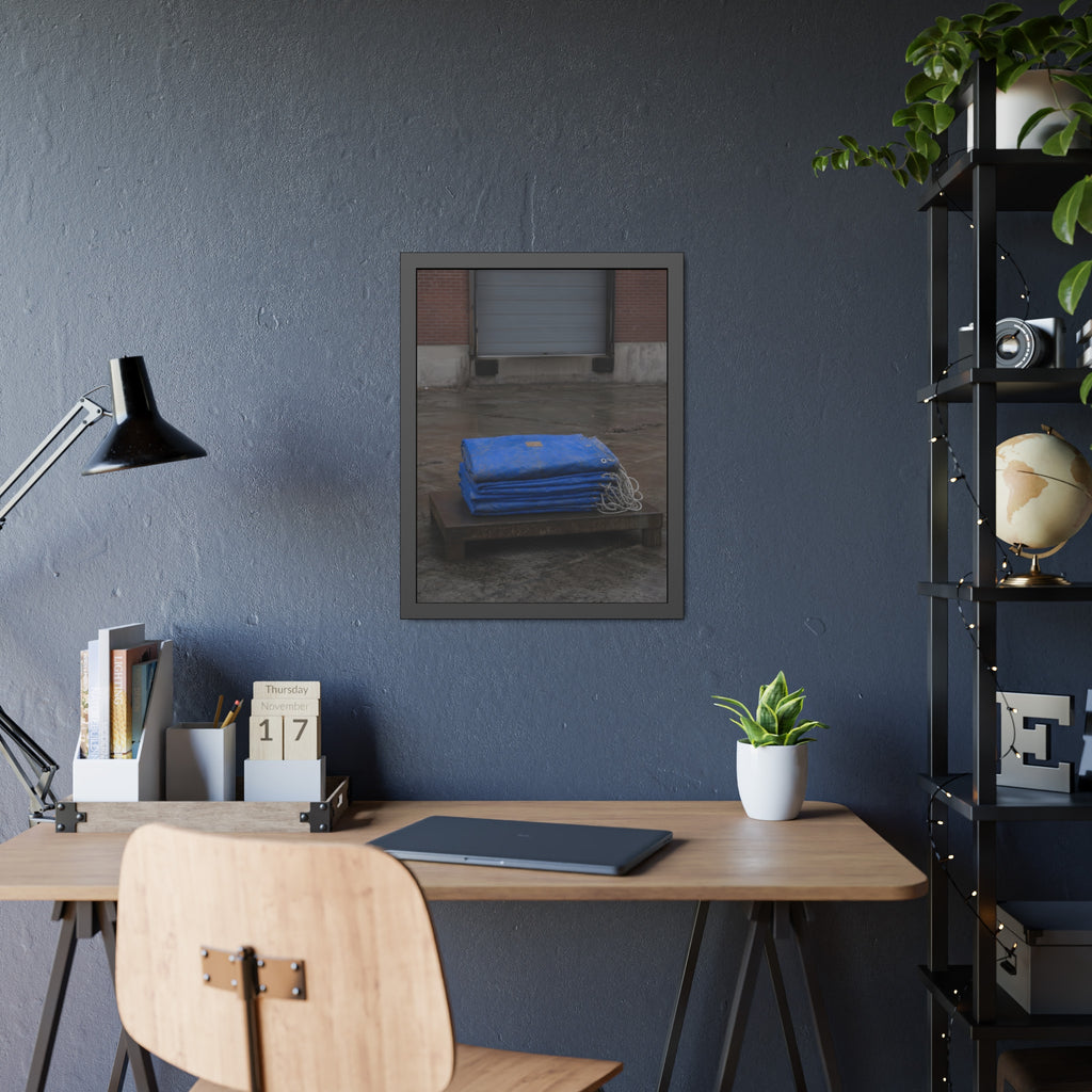 A folded blue tarp stacked on a low wooden platform by a loading dock. The Repaired Fold by Garabaggio, framed fine art print hanging in a room.
