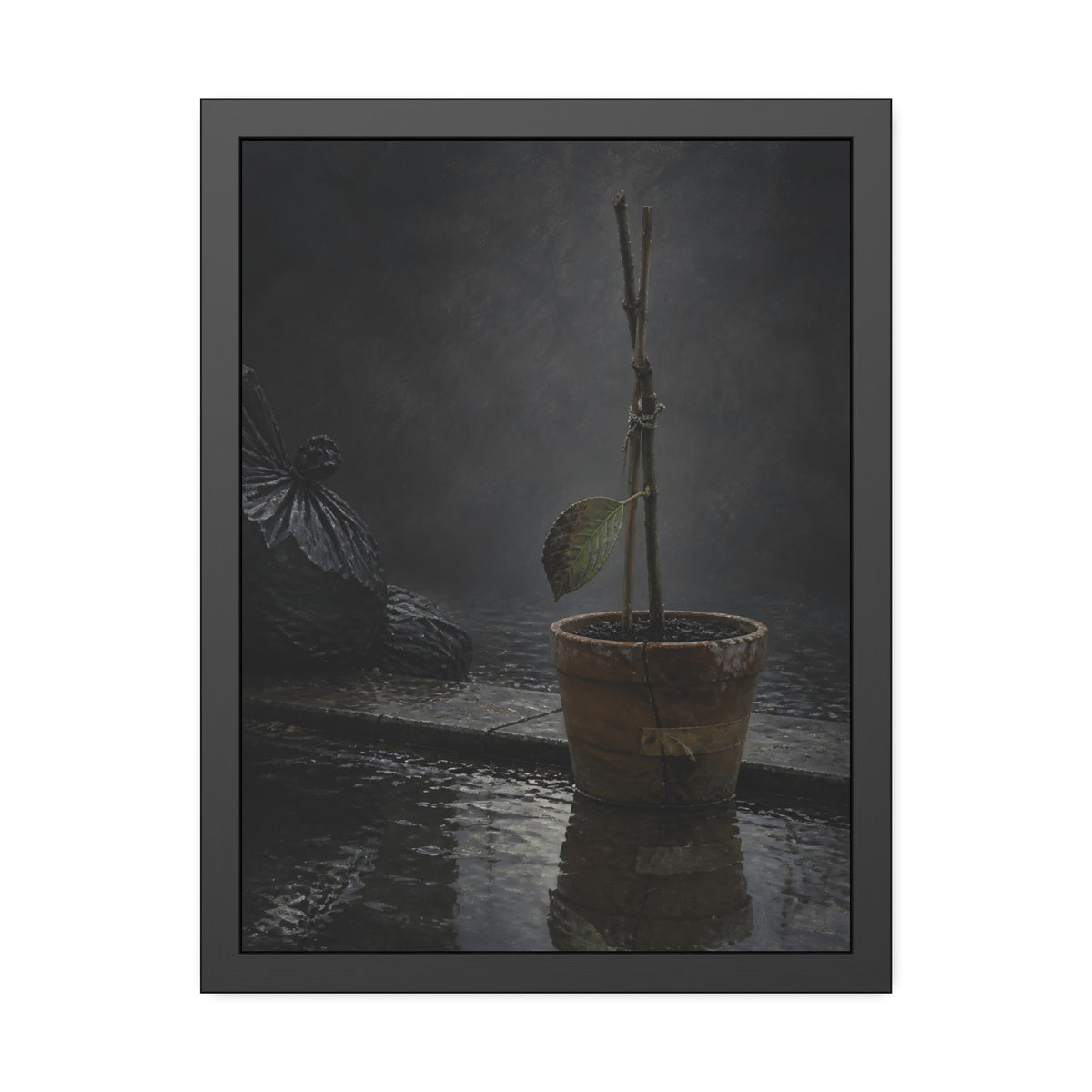 Bare tied stems in a clay pot on flooded pavement, one leaf remaining. The Grey Between by Garabaggio, framed fine art print, 18″ x 24″.