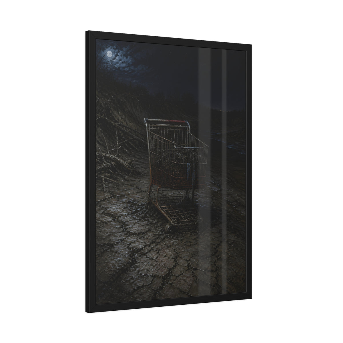 A rusted shopping cart sunk in cracked dried mud under a full moon. The Silting by Garabaggio, framed fine art print hanging in a room.