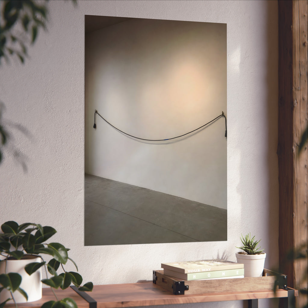An extension cord hung in a long slack curve across a bare white wall. The Unplugged Line by Garabaggio, fine art print hanging in a room.