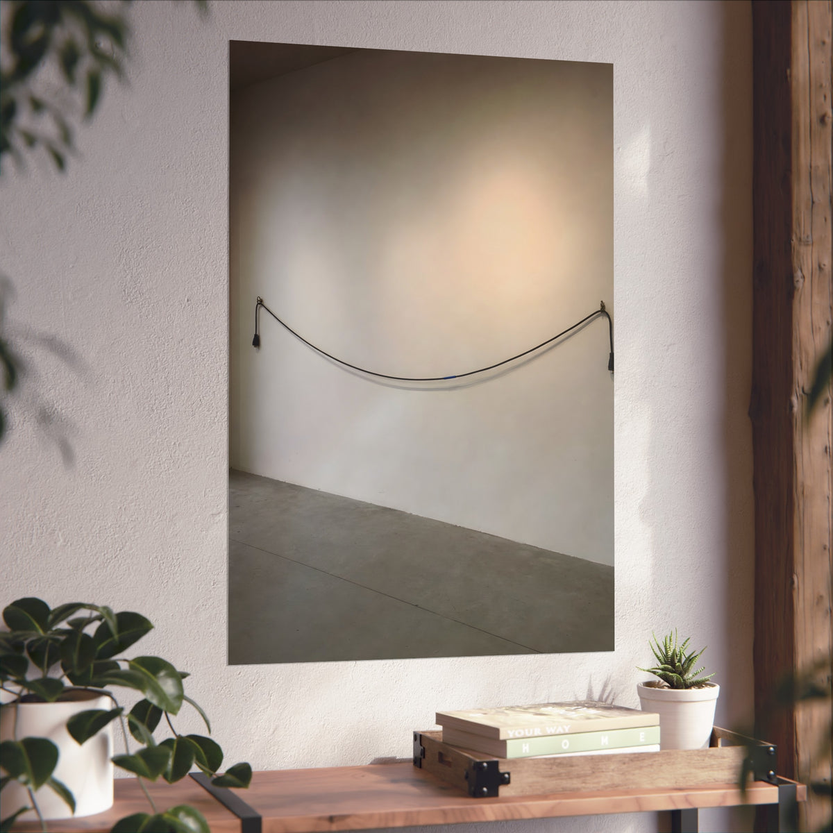 An extension cord hung in a long slack curve across a bare white wall. The Unplugged Line by Garabaggio, fine art print hanging in a room.