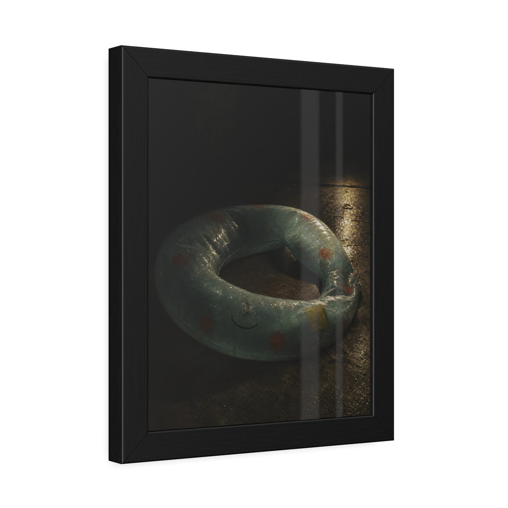 Deflated pool float ring on wet ground, lit from one side in the dark. After the Last Swim by Garabaggio, framed fine art print hanging in a room.