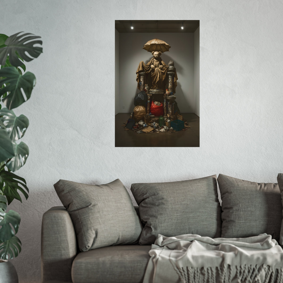 A teddy bear figure under an umbrella atop a pile of trash bags. Madonna of the Lost and Found by Garabaggio, fine art print hanging in a room.