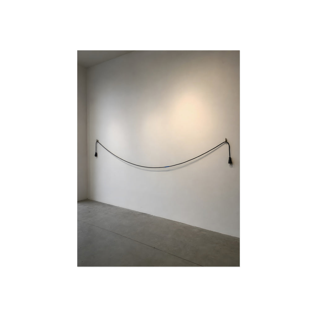 An extension cord hung in a long slack curve across a bare white wall. The Unplugged Line by Garabaggio, fine art print, 12″ x 16″.