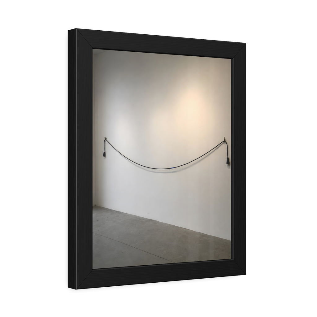 An extension cord hung in a long slack curve across a bare white wall. The Unplugged Line by Garabaggio, framed fine art print hanging in a room.