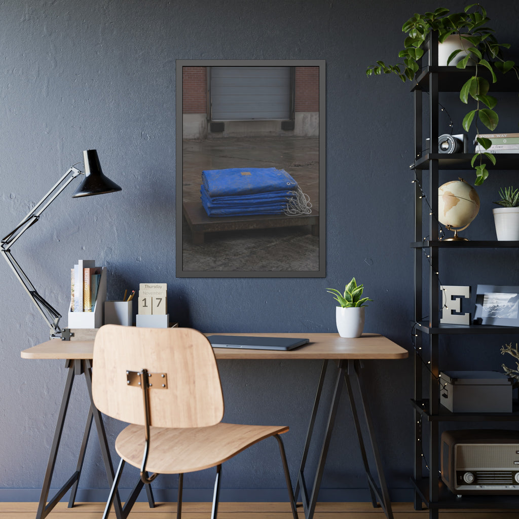 A folded blue tarp stacked on a low wooden platform by a loading dock. The Repaired Fold by Garabaggio, framed fine art print hanging in a room.