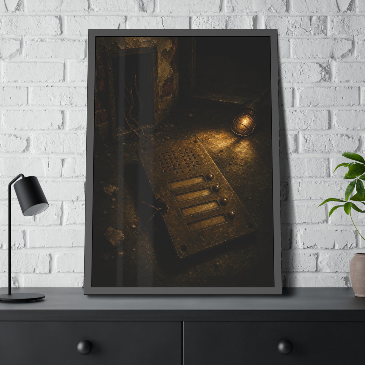 An intercom panel face up on a floor, wires cut, lit by a work lamp. The Plate Taken Down by Garabaggio, framed fine art print hanging in a room.