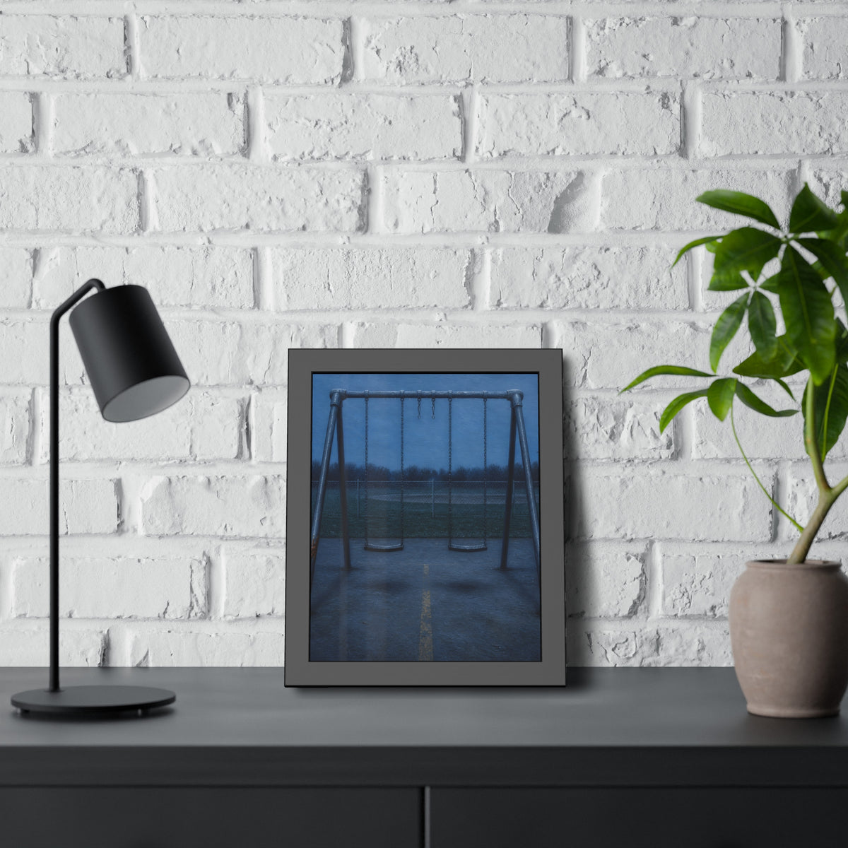 A swing set at dusk with two seats hanging straight. The Sixth Hour: The Seat Hanging Straight by Garabaggio, framed fine art print hanging in a room.