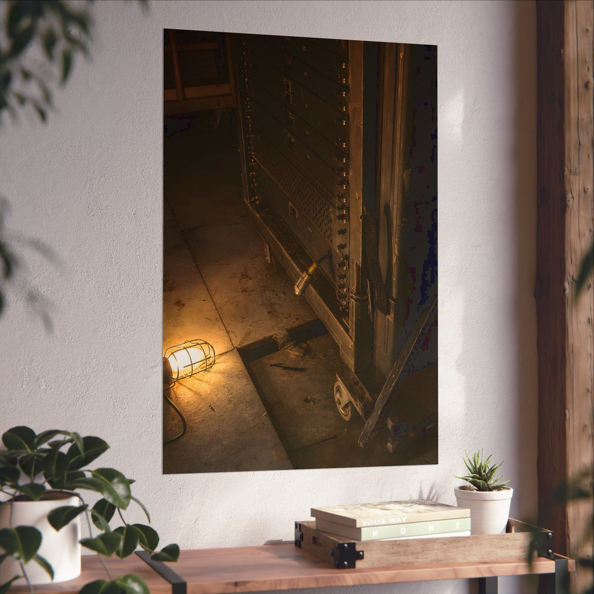 A server rack on a concrete floor beside a caged work light. The Silence at Cutover by Garabaggio, fine art print hanging in a room.