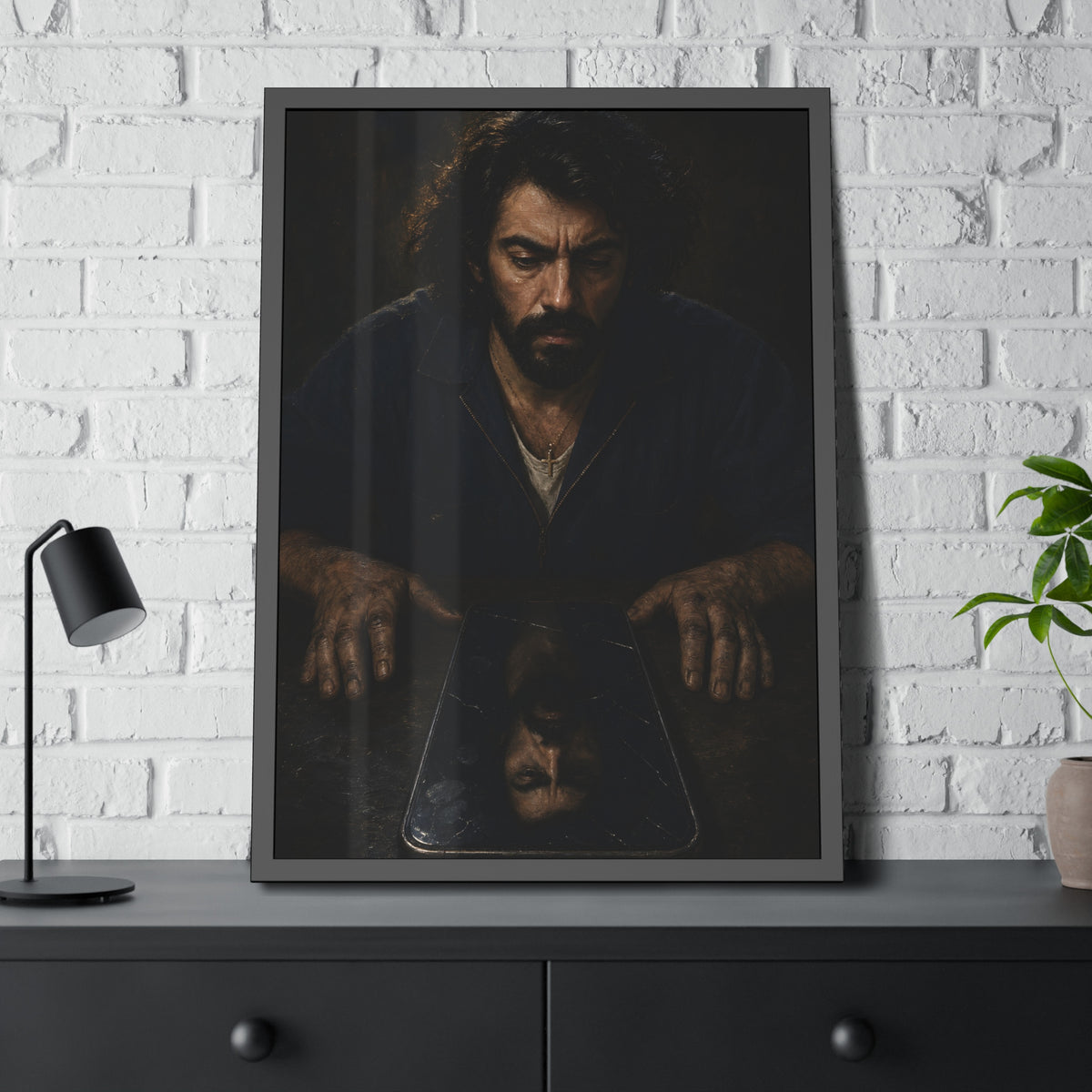 A bearded man in coveralls looking down at his face in a cracked screen. The Mirror After Midnight by Garabaggio, framed fine art print hanging in a room.