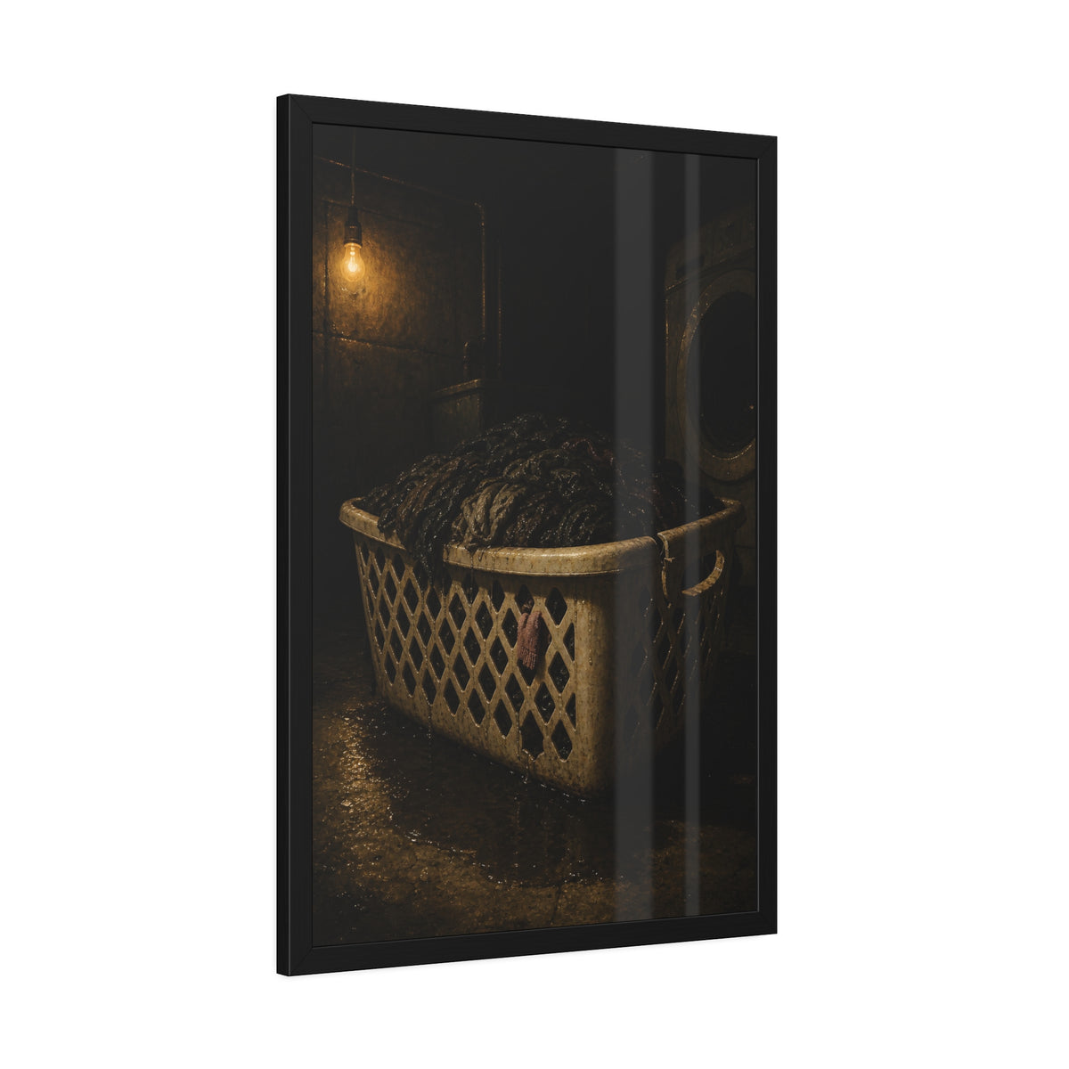 A laundry basket heaped with wet dark clothes under a bare bulb. The Burden of Wet Clothes by Garabaggio, framed fine art print hanging in a room.