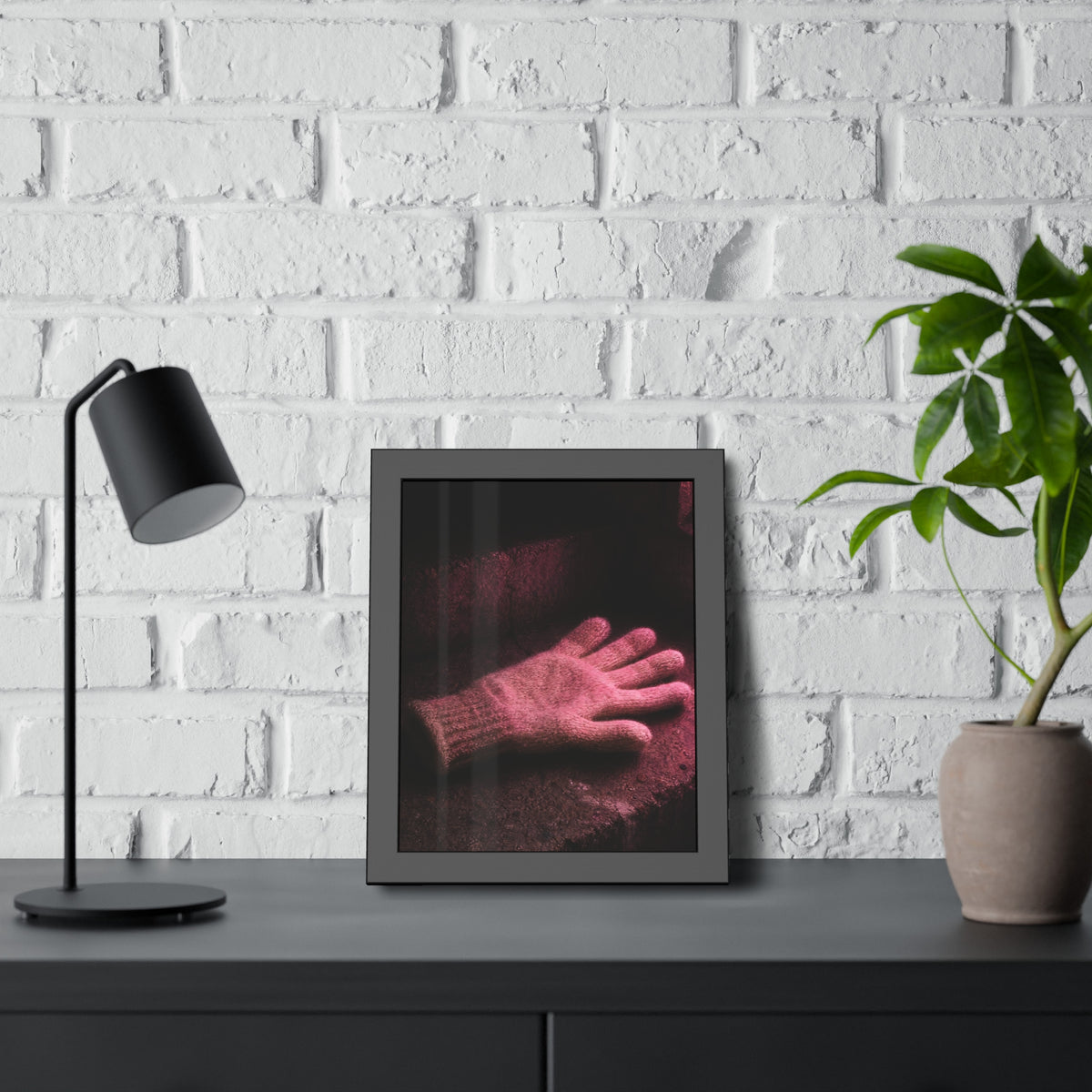 A knitted glove lying flat on a concrete step under pink light. The Vigil in Pink Light by Garabaggio, framed fine art print hanging in a room.