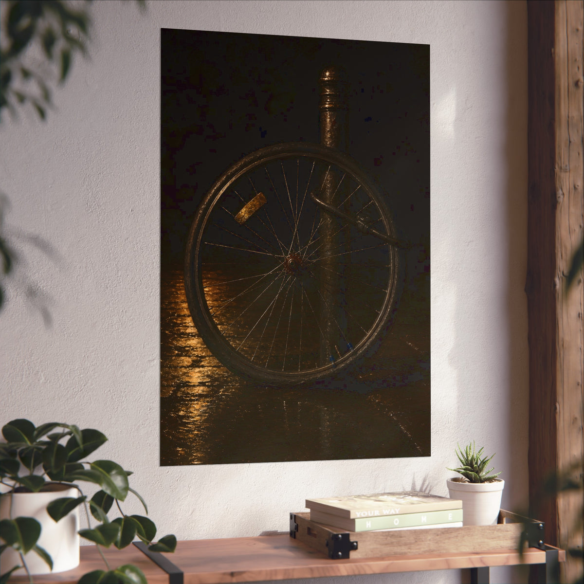 A bare bicycle wheel locked to a post on wet pavement. The Wheel Without a Bicycle by Garabaggio, fine art print hanging in a room.