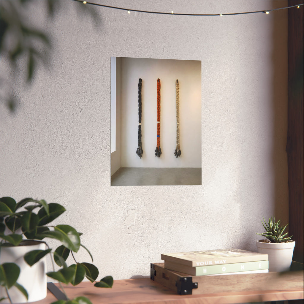 Three braided bundles of extension cords hung on a white gallery wall. The Braided Triptych by Garabaggio, fine art print hanging in a room.