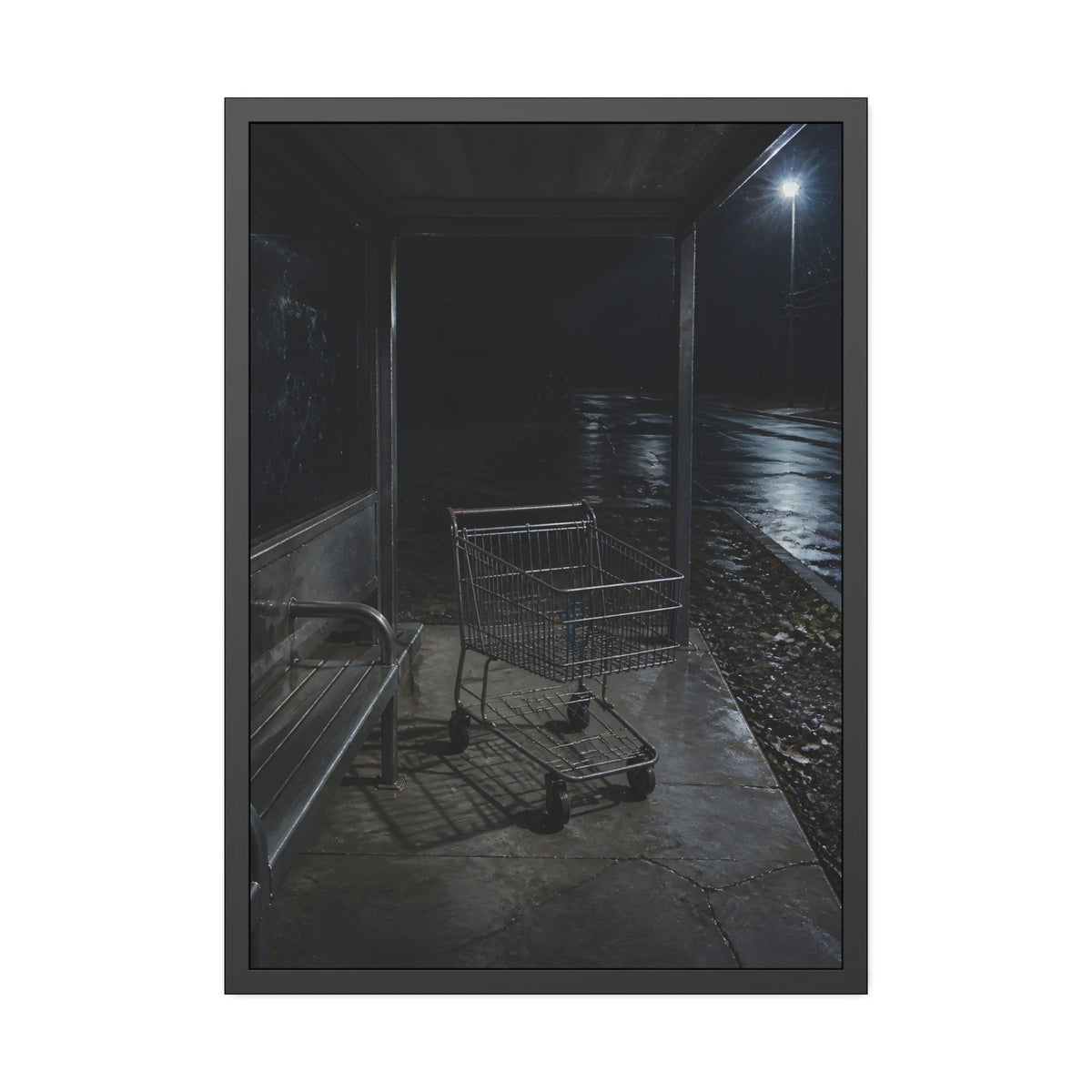 A shopping cart parked inside a bus shelter under a street lamp at night. The Rest at the Bus Shelter by Garabaggio, framed fine art print, 28″ x 40″.