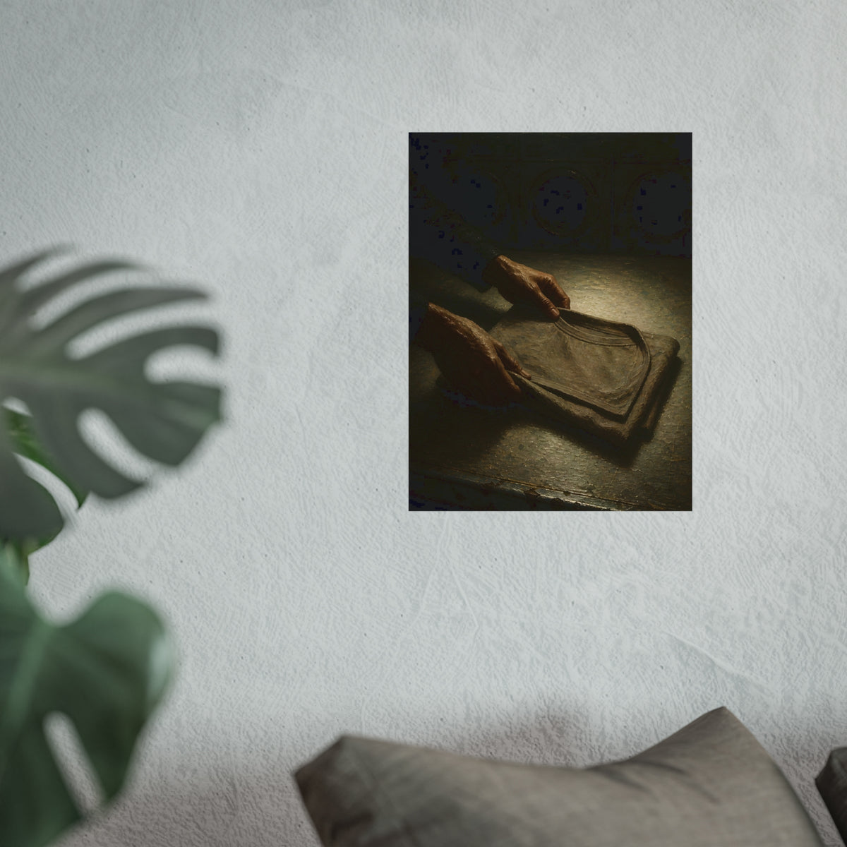 Two hands folding a shirt on a laundromat table with washers behind. The Folding at Two A.M by Garabaggio, fine art print hanging in a room.