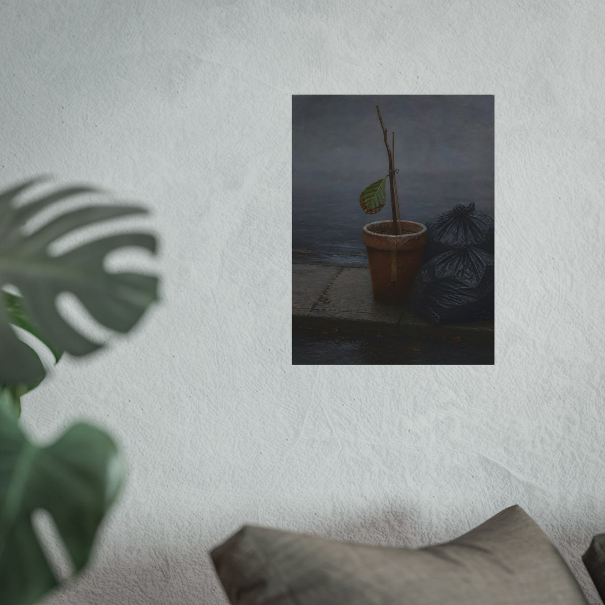 A potted dead twig with one leaf beside black garbage bags on a wet curb. The Curb on Tuesday by Garabaggio, fine art print hanging in a room.