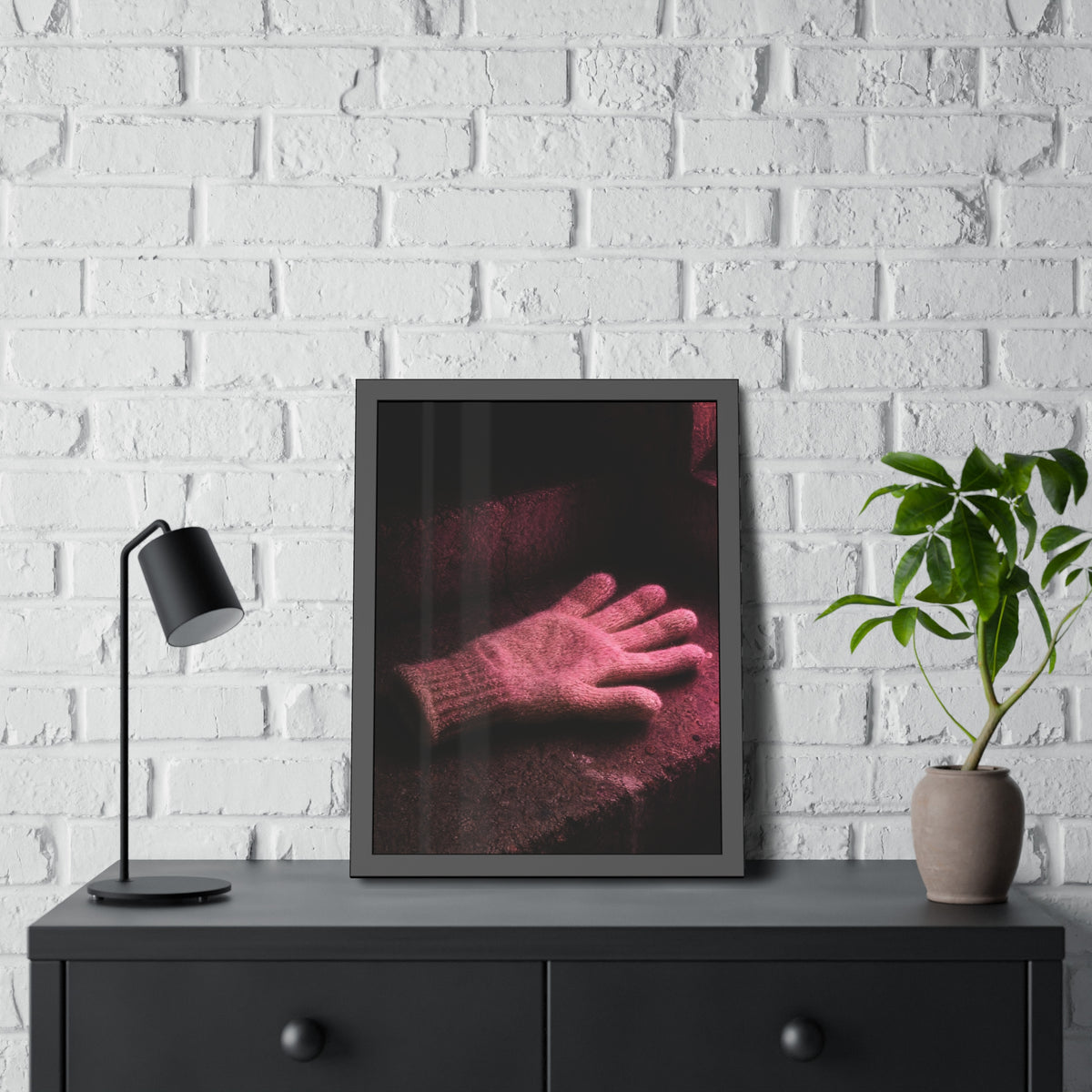 A knitted glove lying flat on a concrete step under pink light. The Vigil in Pink Light by Garabaggio, framed fine art print hanging in a room.