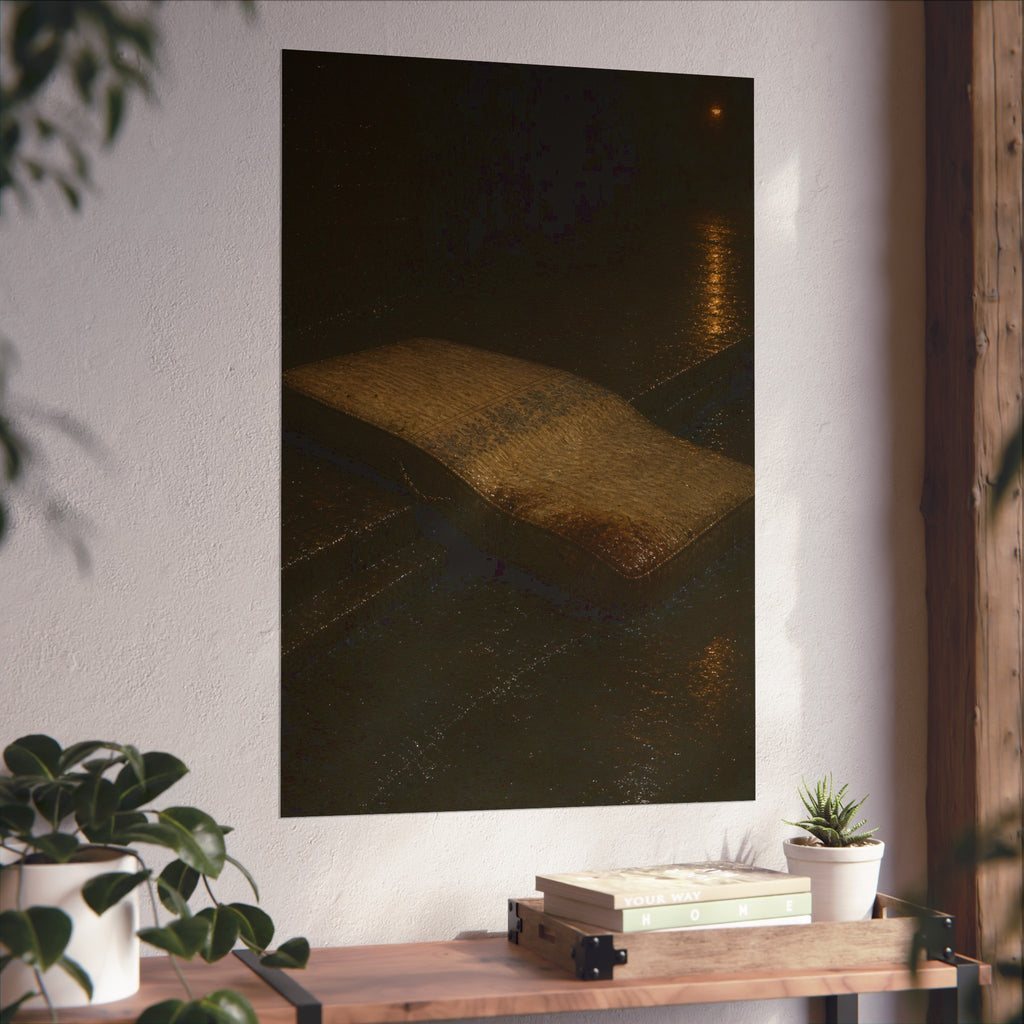 A sodden mattress slumped off a curb on wet pavement under a street lamp. The Collapse into the Gutter by Garabaggio, fine art print hanging in a room.