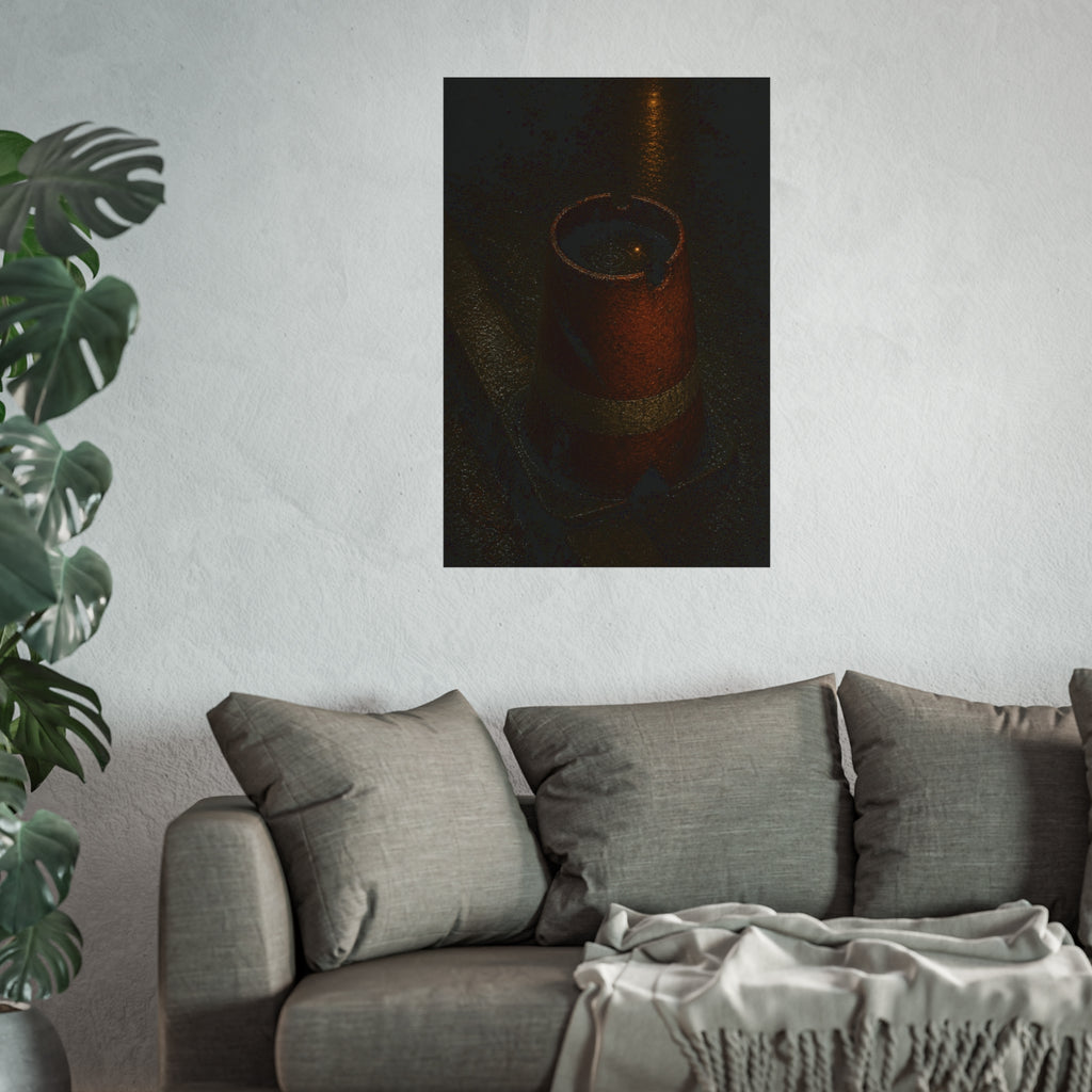 An upturned traffic cone holding rainwater at a wet curb under a lamp. The Cup of Rain by Garabaggio, fine art print hanging in a room.