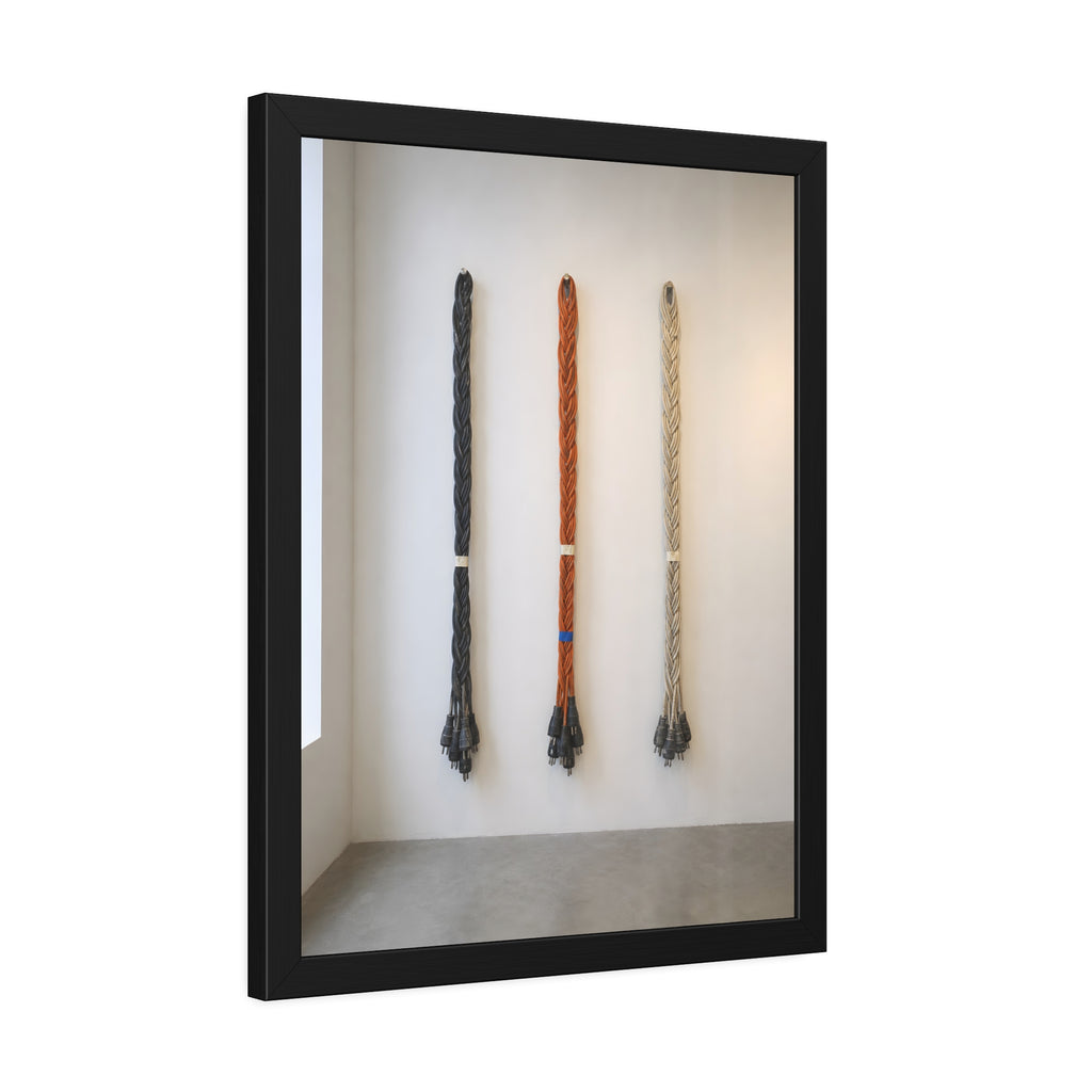Three braided bundles of extension cords hung on a white gallery wall. The Braided Triptych by Garabaggio, framed fine art print hanging in a room.