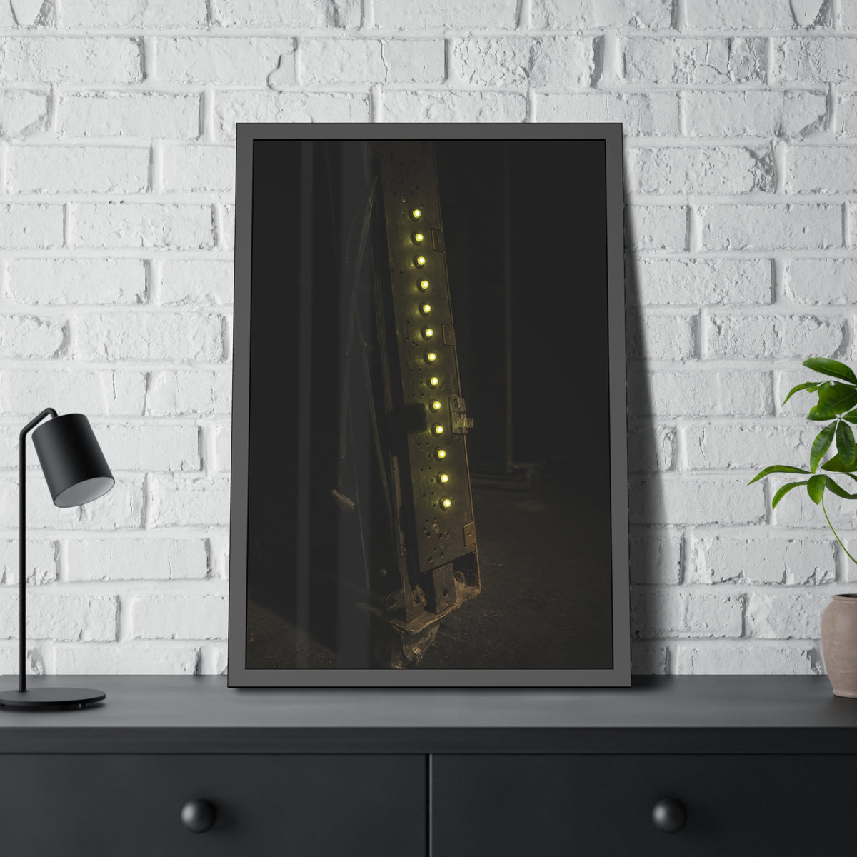 A dark rack panel with a vertical row of glowing green indicator lights. The First Green Choir by Garabaggio, framed fine art print hanging in a room.