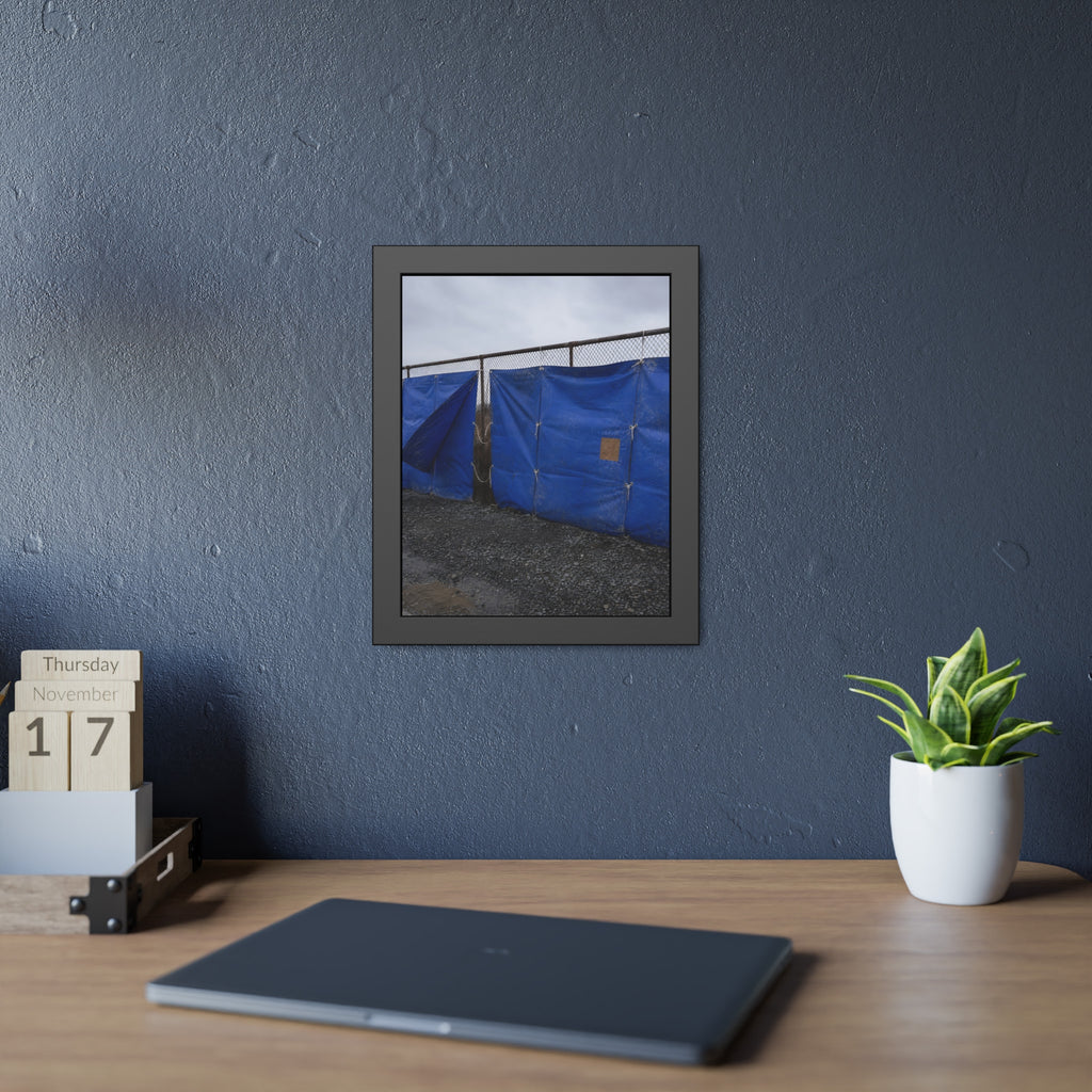 Blue tarps lashed to a chain link fence above gravel under grey sky. Drapery on the Fence by Garabaggio, framed fine art print hanging in a room.