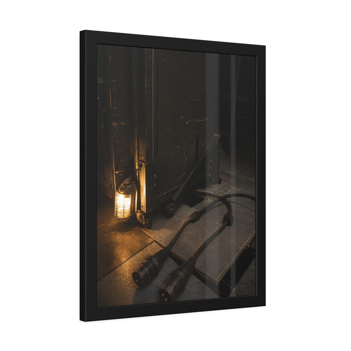 Two thick power cables unplugged on the floor beside a caged work lamp. The Redundant Power by Garabaggio, framed fine art print hanging in a room.