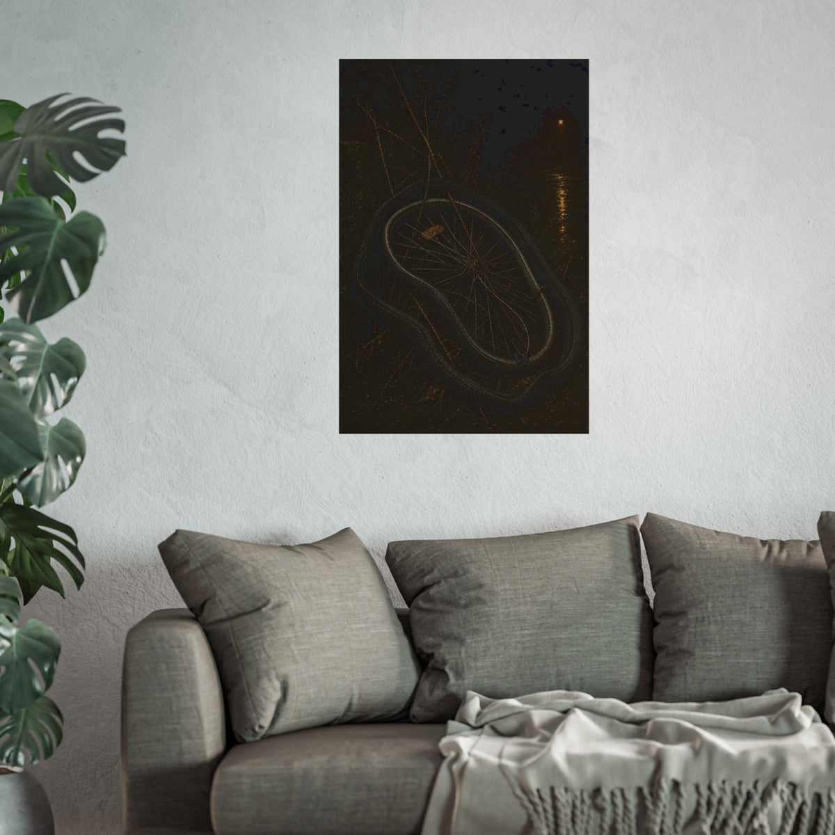 A bare bicycle wheel with its tire coiled around it on wet ground. The Removal of the Tire by Garabaggio, fine art print hanging in a room.