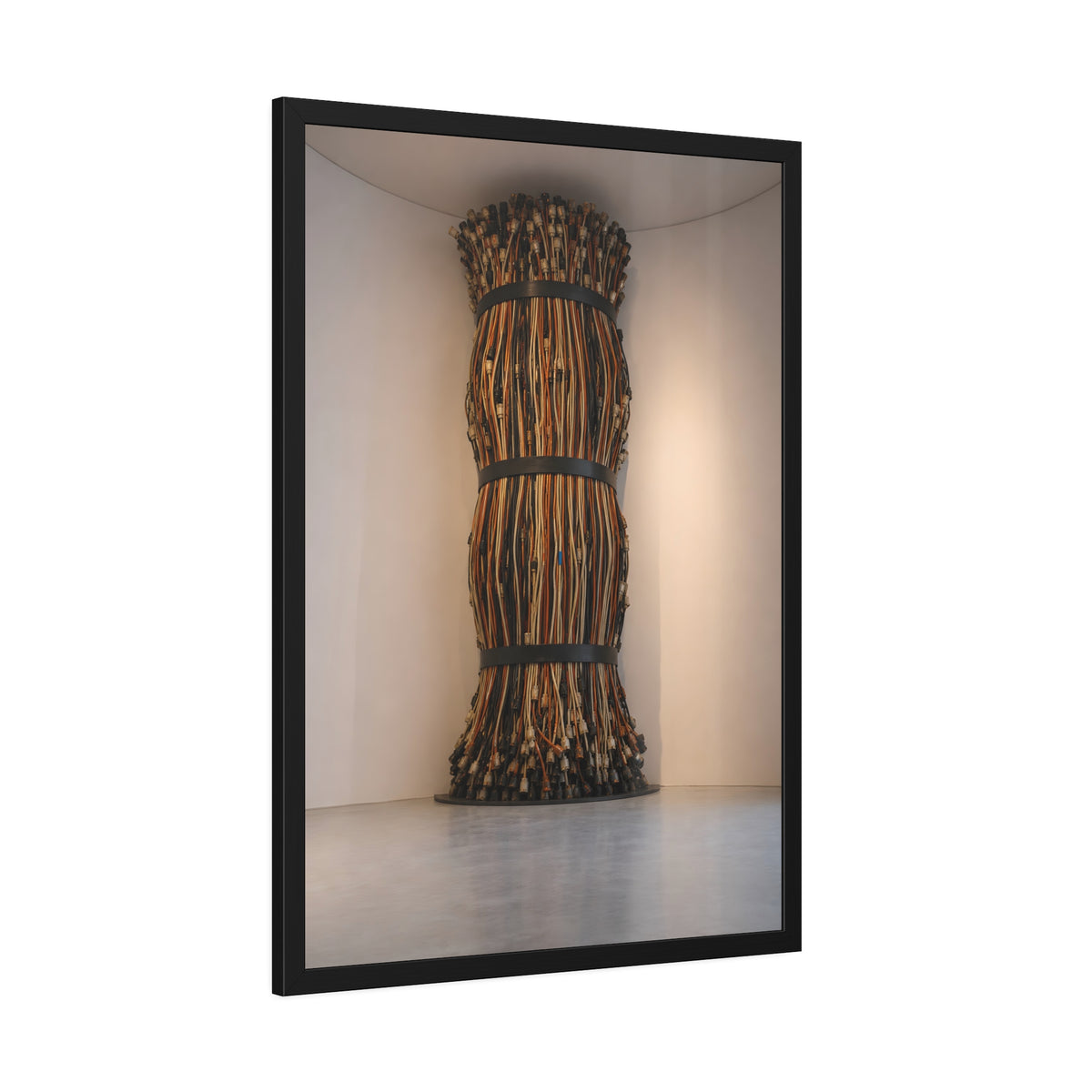 A tall column of bundled cords strapped in three places in a gallery corner. The Bundled Apse by Garabaggio, framed fine art print hanging in a room.