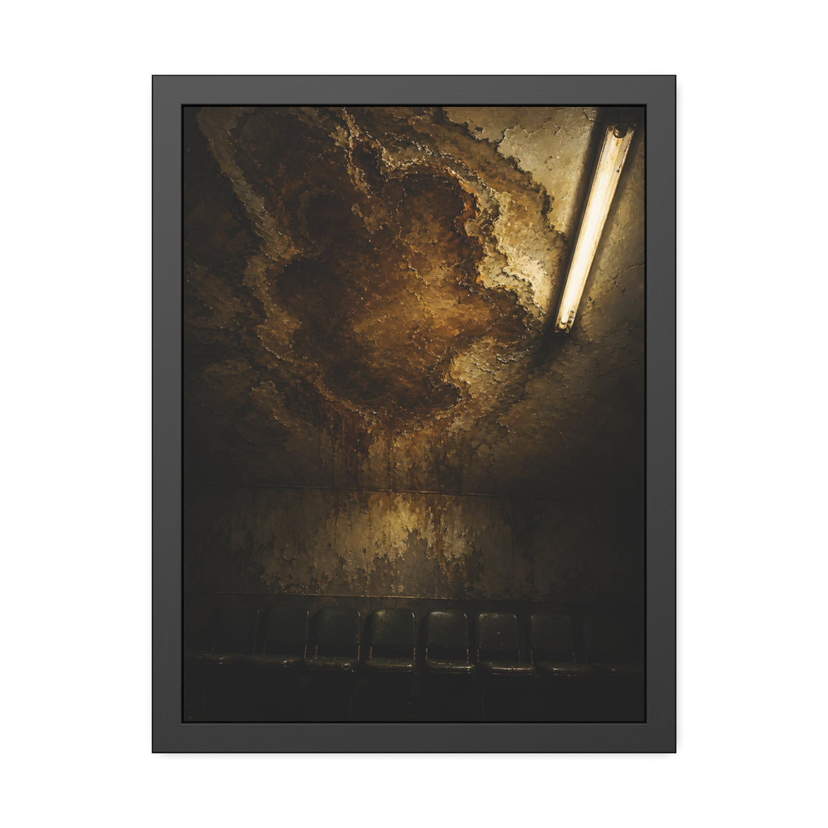 A brown water stain spreading across a ceiling above a row of chairs. The Stain Above the Row by Garabaggio, framed fine art print, 18″ x 24″.