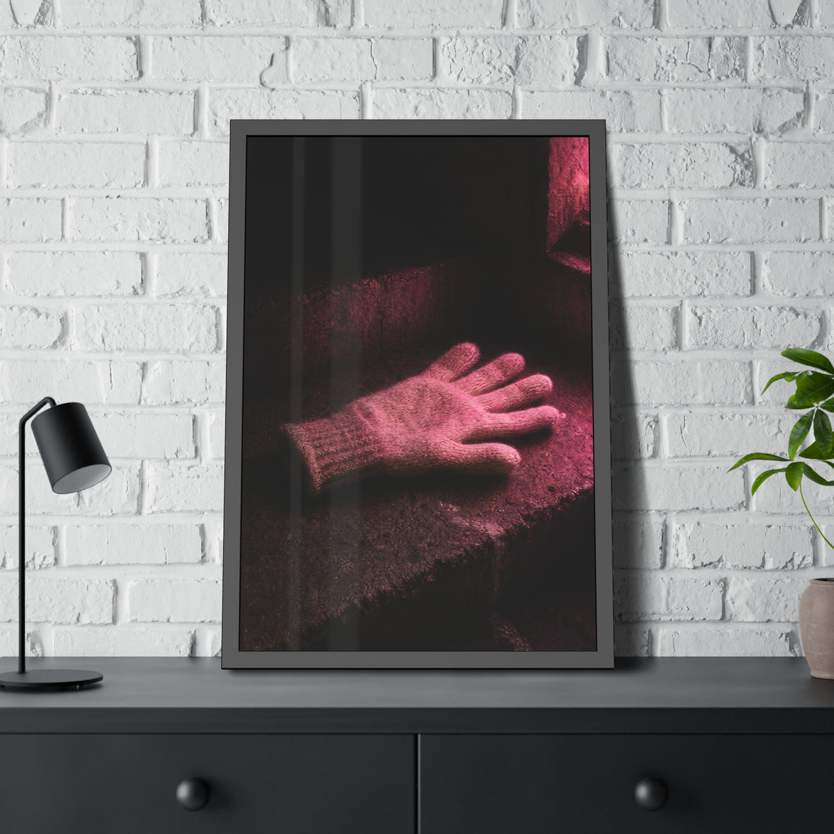 A knitted glove lying flat on a concrete step under pink light. The Vigil in Pink Light by Garabaggio, framed fine art print hanging in a room.