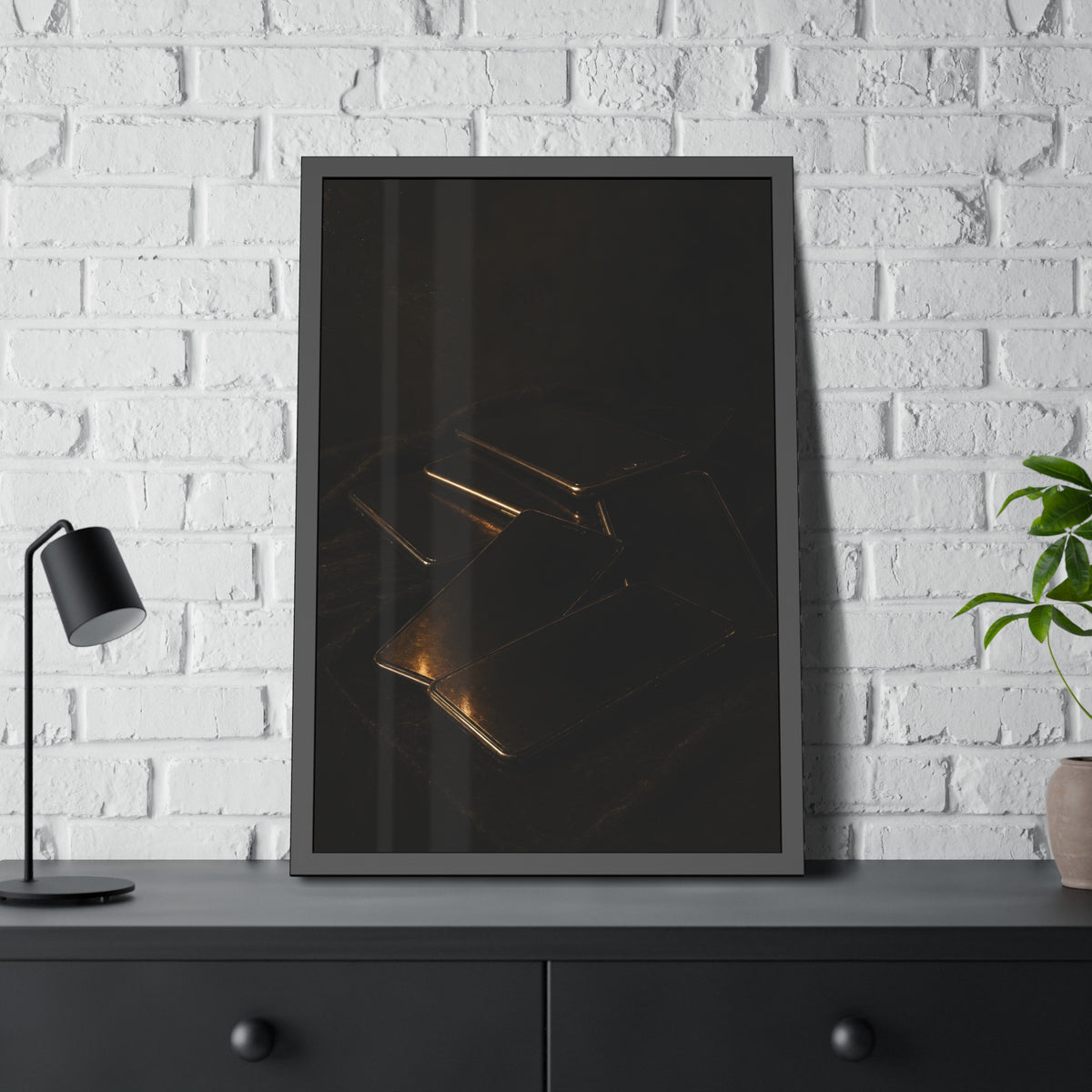 Stack of dead phone screens on dark cloth, edges catching warm light. After the Light Goes Out by Garabaggio, framed fine art print hanging in a room.