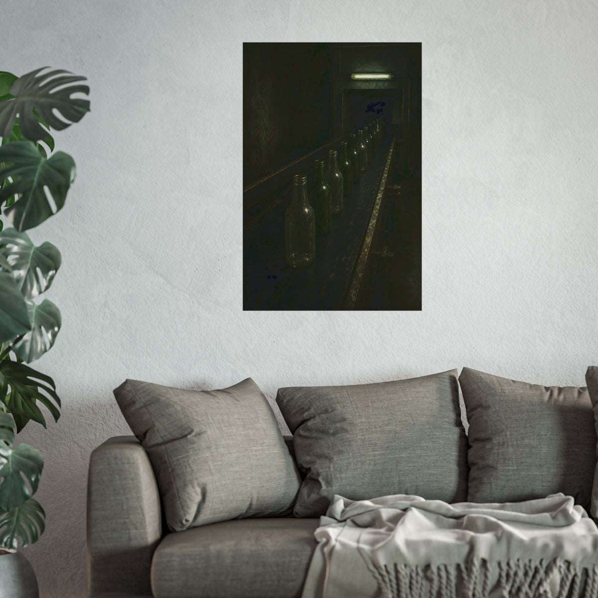 Empty glass bottles in a line on a conveyor under one fluorescent tube. The Procession of Bottles by Garabaggio, fine art print hanging in a room.