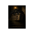 A laundry basket heaped with clothes on stairs under a bare bulb. The Overload on the Basement Stairs by Garabaggio, fine art print, 12″ x 16″.