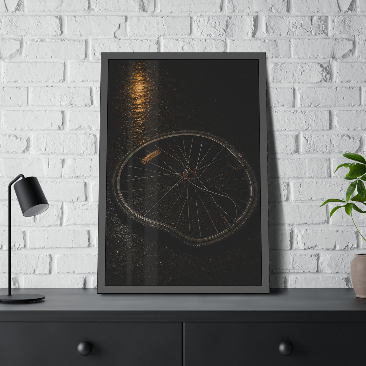 A buckled bicycle wheel on wet asphalt beneath a streetlight reflection. The Bend from Impact by Garabaggio, framed fine art print hanging in a room.